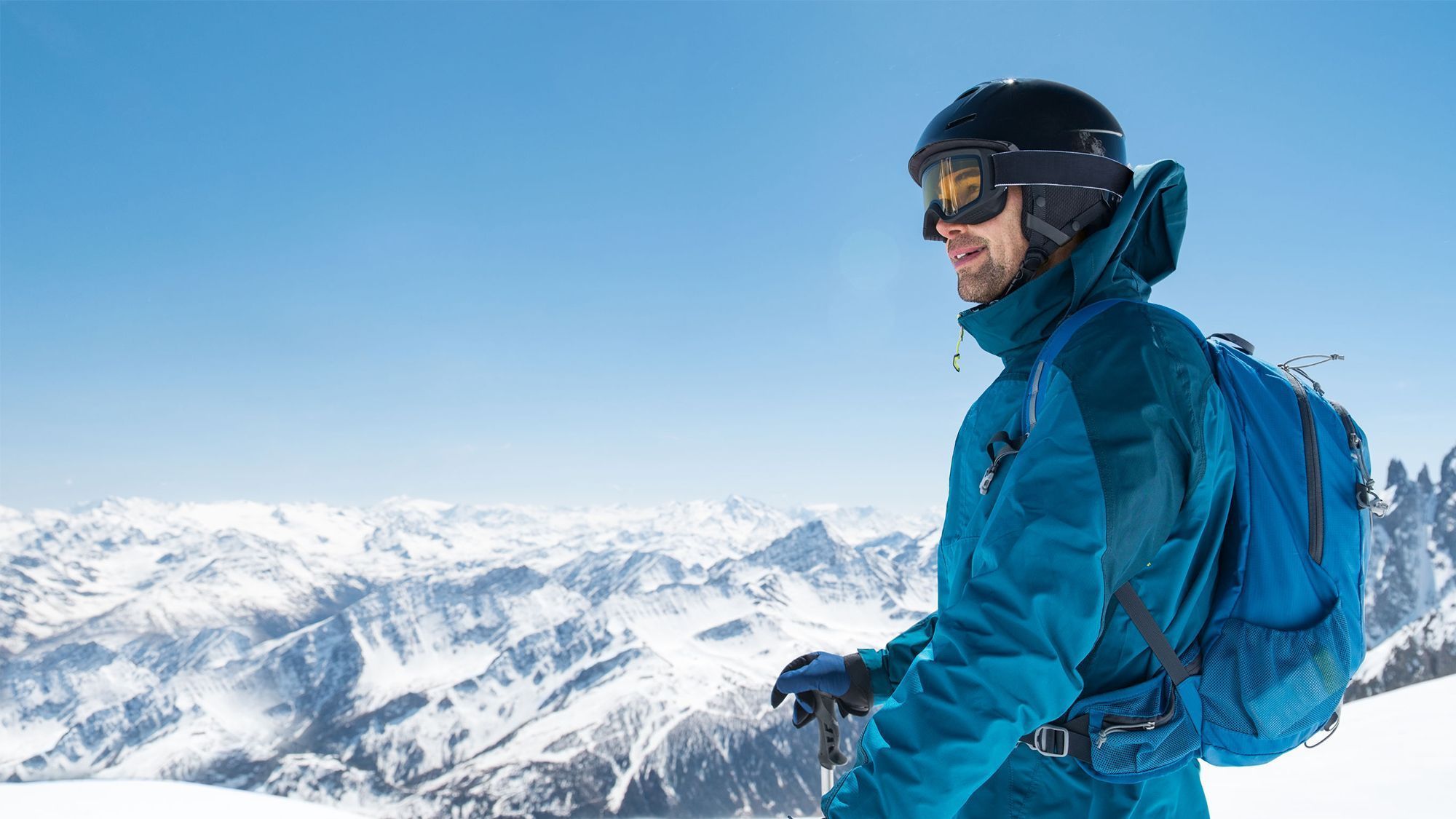 Ein Skifahrer verkleidet mit Point Rent Skiausrüstung schaut auf das Panorama von Livigno